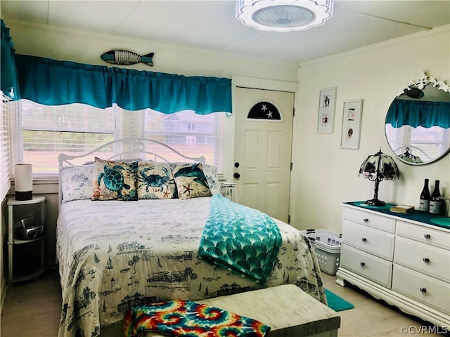 bedroom with multiple windows and light hardwood / wood-style flooring