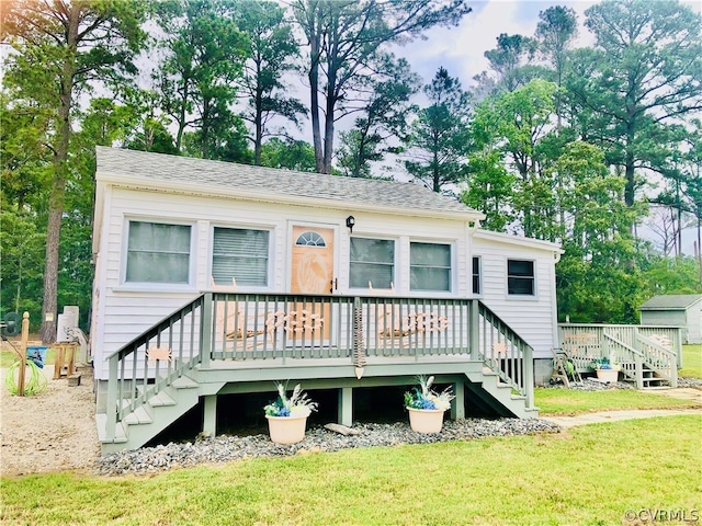 rear view of house with a deck and a yard