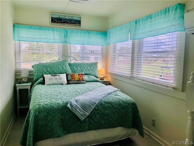 bedroom featuring multiple windows and a wall unit AC