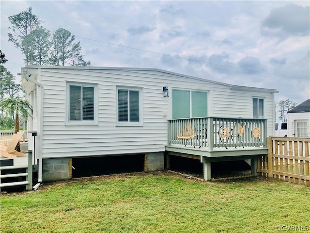 rear view of property with a wooden deck and a yard