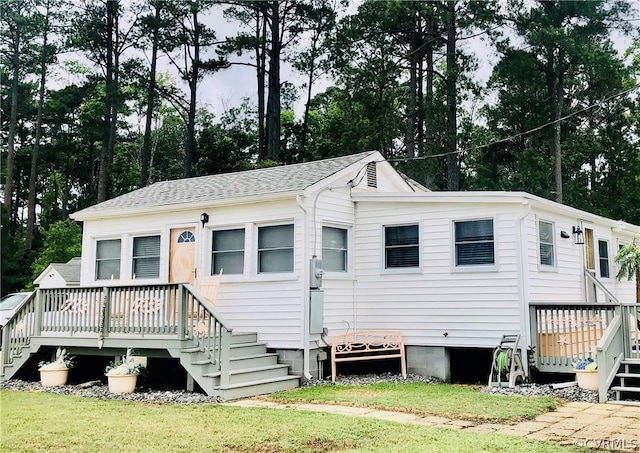 view of front of property with a deck and a front yard