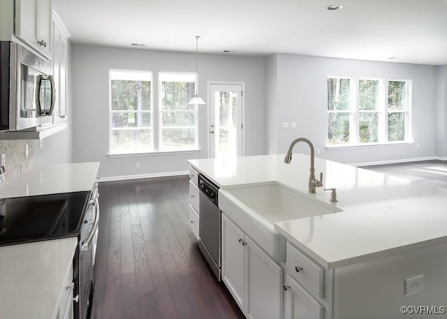 kitchen with pendant lighting, a center island with sink, white cabinets, sink, and stainless steel appliances