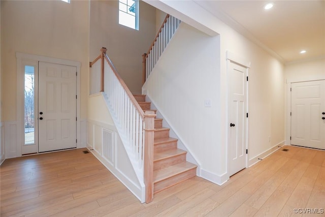 entryway featuring crown molding and light hardwood / wood-style floors