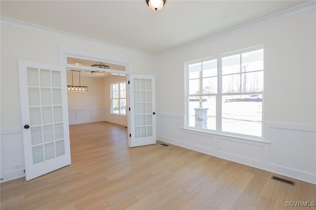 spare room with crown molding, light hardwood / wood-style flooring, and french doors