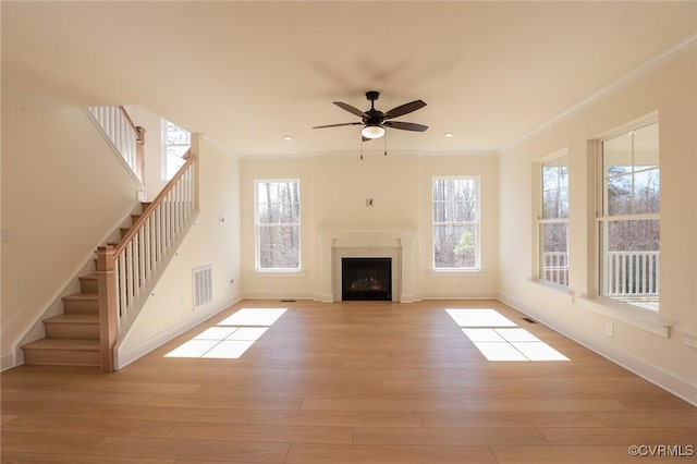 unfurnished living room with light hardwood / wood-style flooring, ornamental molding, and ceiling fan