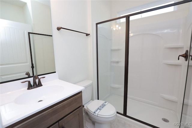 bathroom featuring toilet, a shower with door, and vanity