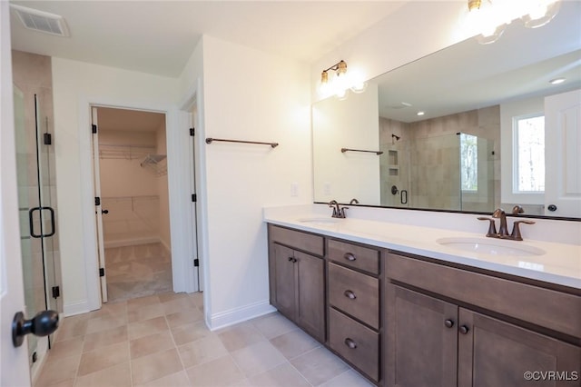 bathroom with tile patterned floors, vanity, and walk in shower