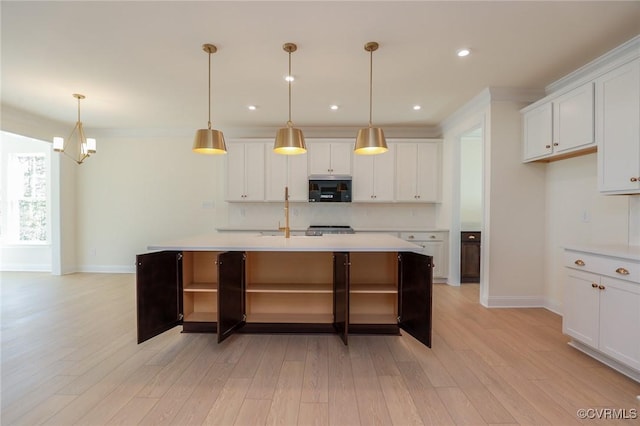 kitchen featuring a center island with sink, light wood-type flooring, decorative light fixtures, white cabinets, and decorative backsplash