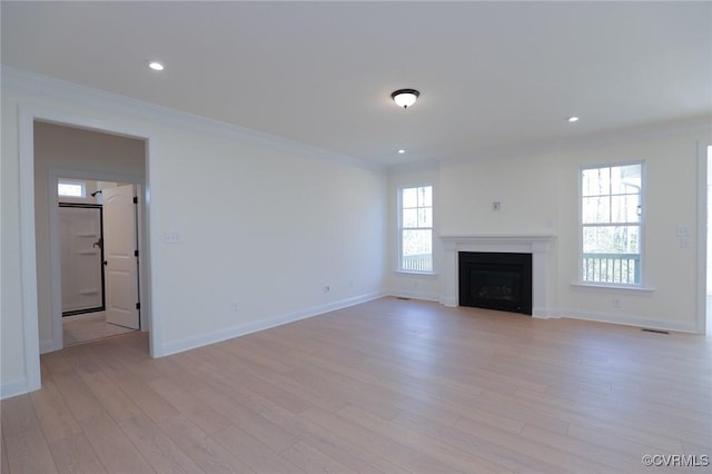 unfurnished living room featuring light hardwood / wood-style flooring and crown molding