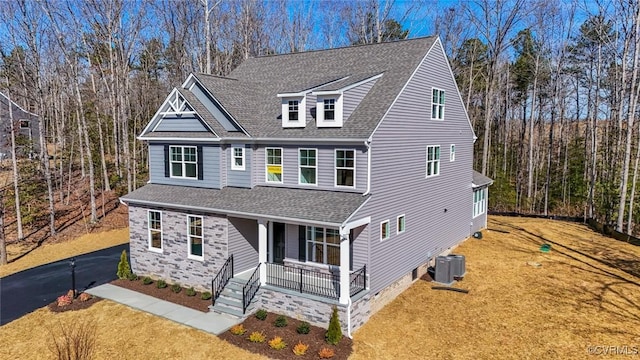 view of front of house with central AC, a front lawn, and a porch