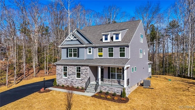 view of front of house with central AC unit, a front lawn, and a porch