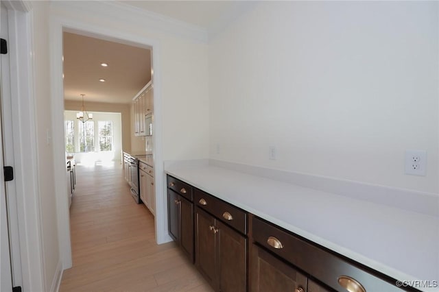 hallway featuring an inviting chandelier and light hardwood / wood-style floors