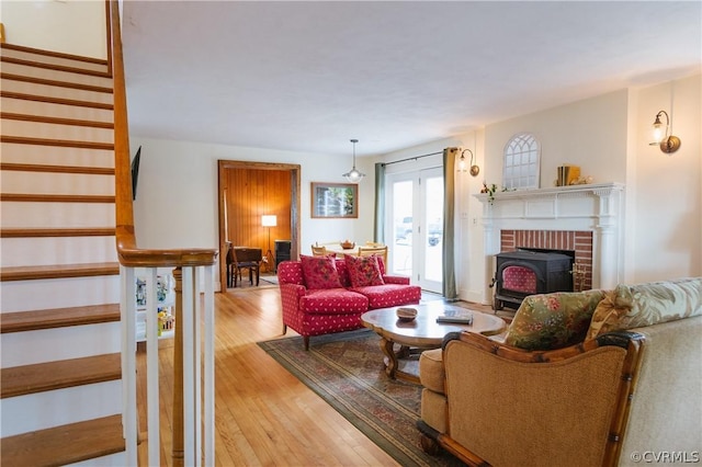 living room with a wood stove and light hardwood / wood-style flooring