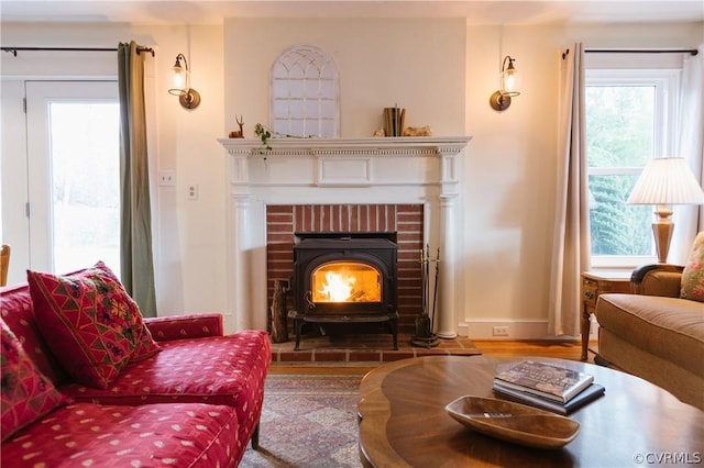 living area with hardwood / wood-style flooring and a wood stove