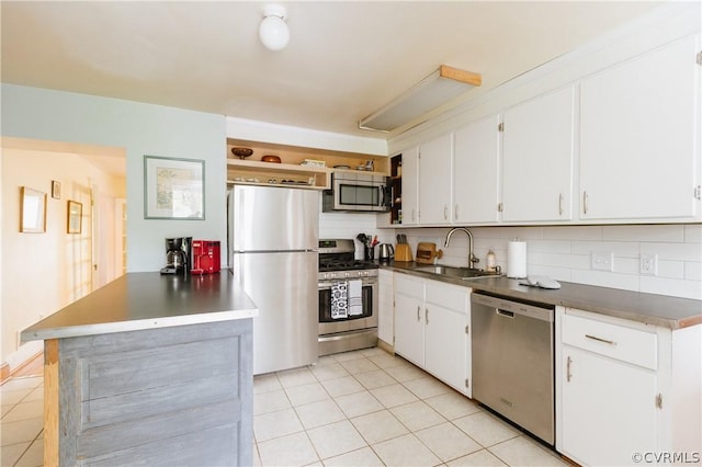 kitchen with light tile patterned floors, decorative backsplash, white cabinetry, appliances with stainless steel finishes, and sink