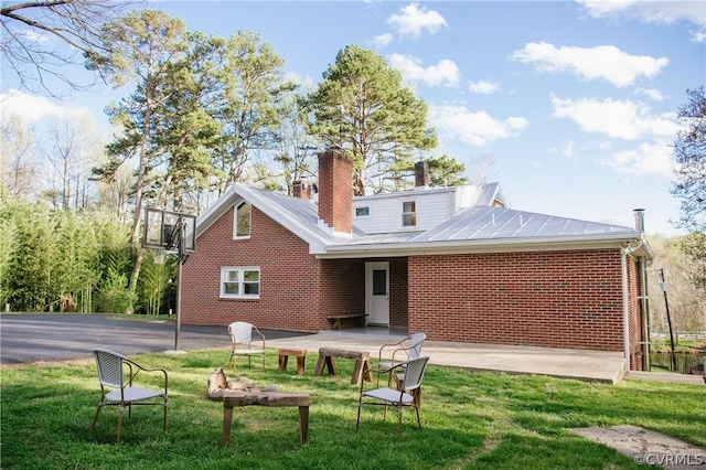 rear view of property with a lawn and a patio area