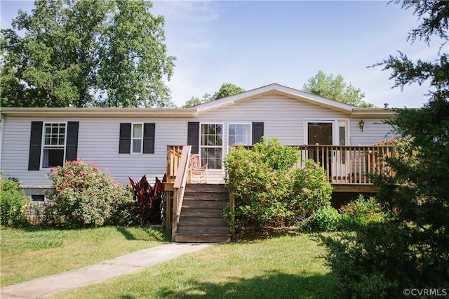 manufactured / mobile home with a front lawn and a wooden deck