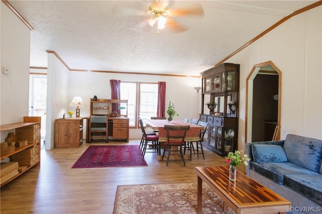 living room with hardwood / wood-style flooring, a textured ceiling, ceiling fan, and ornamental molding