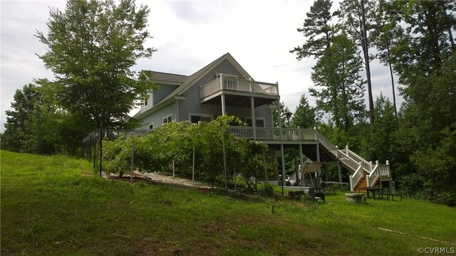 back of house featuring a yard and a balcony