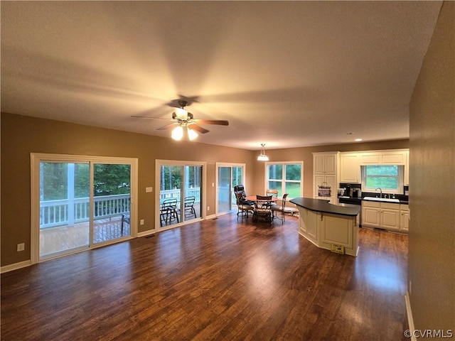 kitchen with sink, dark wood-type flooring, ceiling fan, white cabinetry, and decorative light fixtures