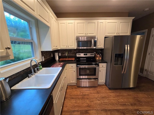 kitchen with sink, dark wood-type flooring, white cabinetry, stainless steel appliances, and tasteful backsplash