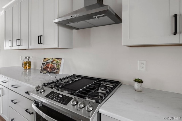 kitchen featuring white cabinets, stainless steel gas stove, and wall chimney exhaust hood