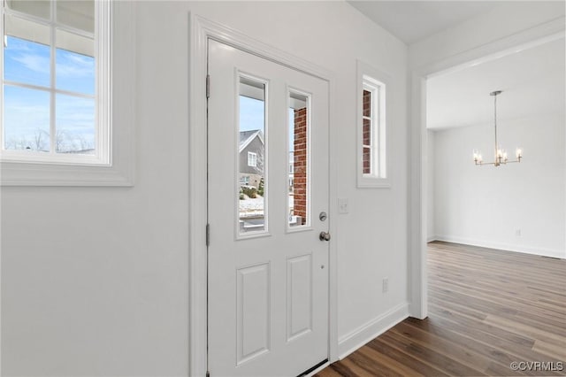 entrance foyer with dark wood-type flooring and an inviting chandelier