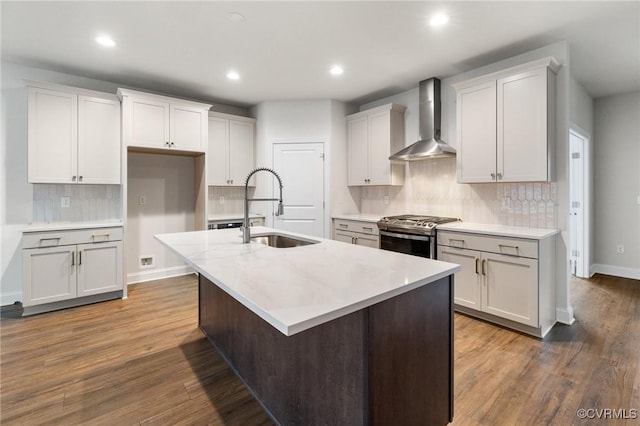 kitchen with sink, a kitchen island with sink, wall chimney exhaust hood, and stainless steel gas range