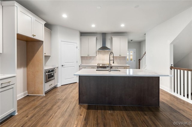 kitchen with dark hardwood / wood-style flooring, sink, oven, white cabinets, and wall chimney exhaust hood