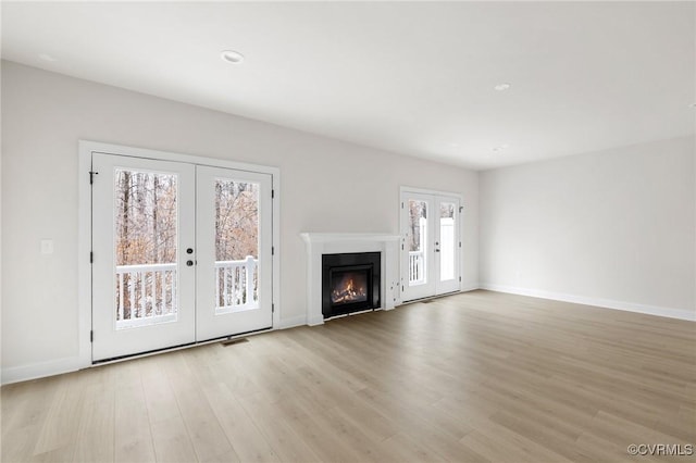 unfurnished living room featuring light hardwood / wood-style flooring and french doors