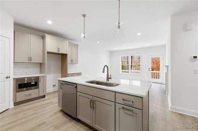 kitchen featuring sink, gray cabinets, hanging light fixtures, and stainless steel appliances