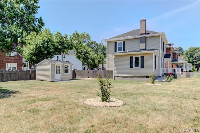 back of property featuring a yard and a storage shed