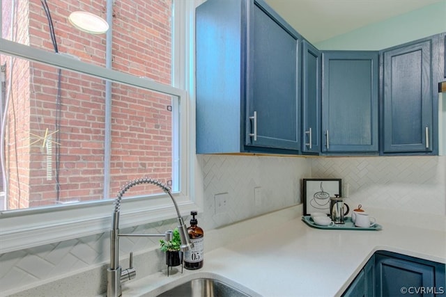 kitchen featuring blue cabinetry, sink, and decorative backsplash