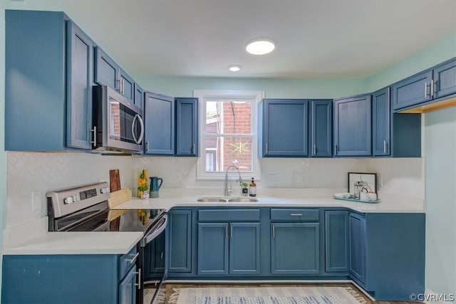 kitchen featuring sink, stainless steel appliances, and blue cabinets