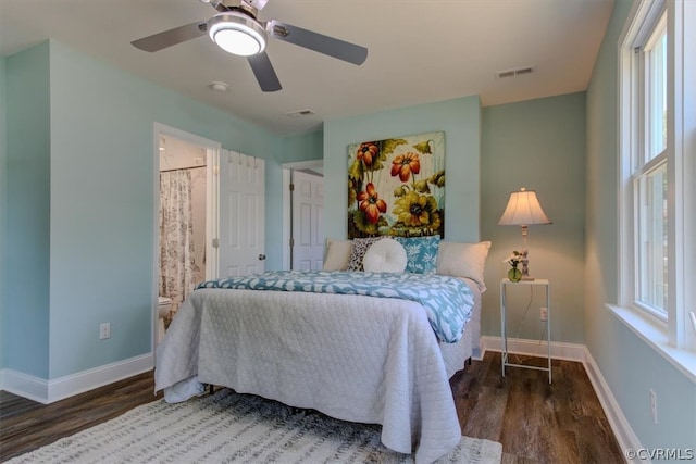 bedroom with ceiling fan, ensuite bathroom, and dark hardwood / wood-style flooring