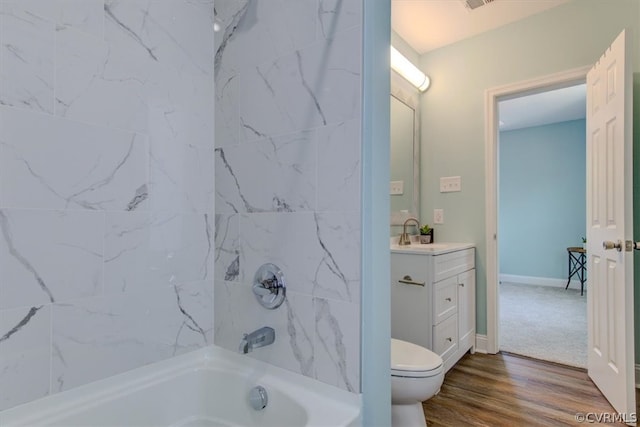 full bathroom featuring vanity, tiled shower / bath, wood-type flooring, and toilet