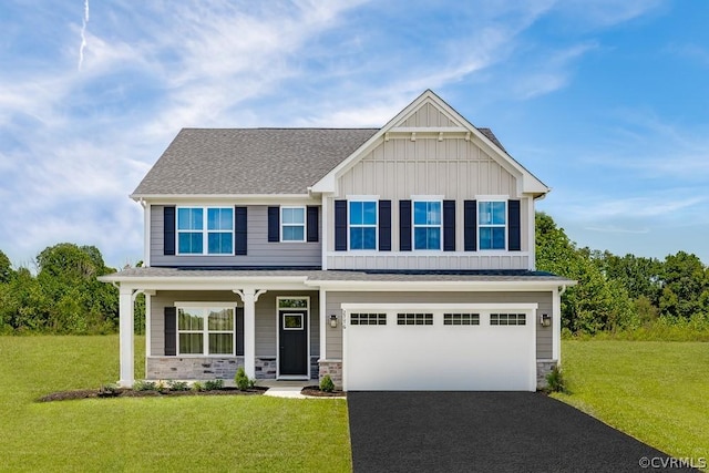 craftsman inspired home featuring a garage and a front lawn