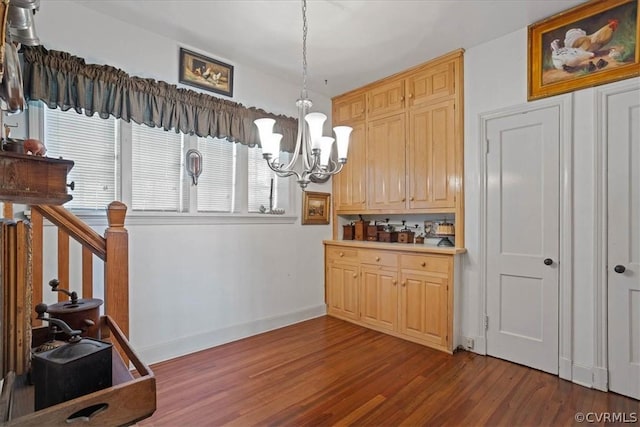 kitchen featuring light brown cabinetry, a notable chandelier, hanging light fixtures, and hardwood / wood-style floors