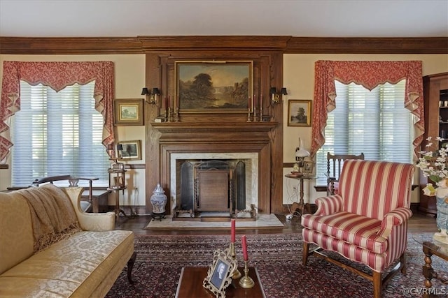 living area with a healthy amount of sunlight, a fireplace, and hardwood / wood-style flooring