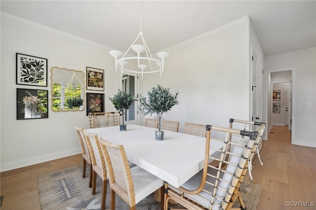 dining space featuring ornamental molding, light hardwood / wood-style floors, and a chandelier