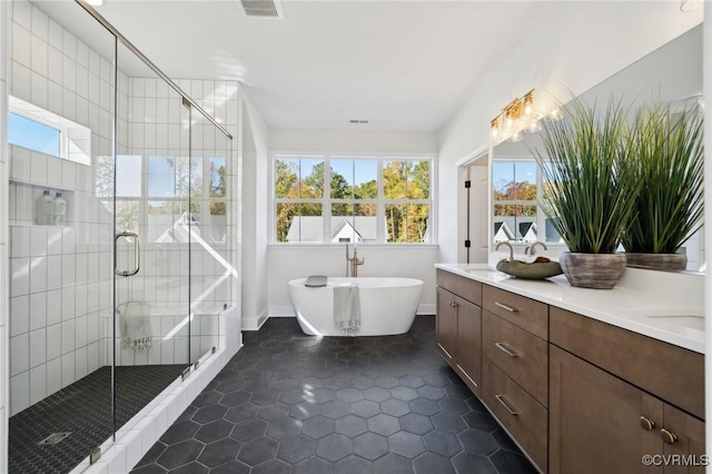 bathroom with independent shower and bath, vanity, and tile patterned floors