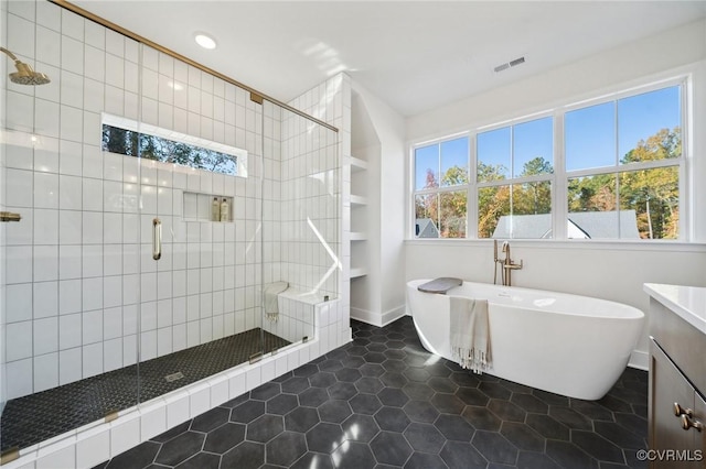 bathroom featuring tile patterned flooring, vanity, and shower with separate bathtub