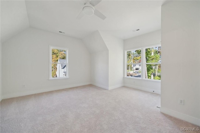 additional living space featuring vaulted ceiling, light colored carpet, and ceiling fan