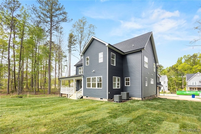 rear view of house featuring cooling unit, a porch, and a lawn