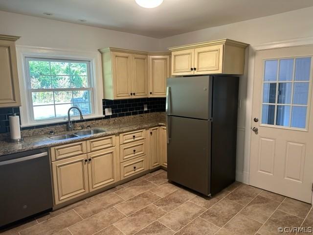 kitchen featuring tasteful backsplash, dishwasher, black refrigerator, and sink