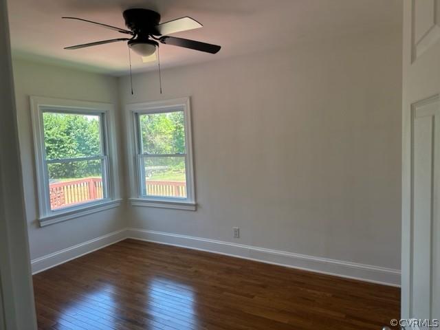 empty room featuring dark hardwood / wood-style flooring and ceiling fan