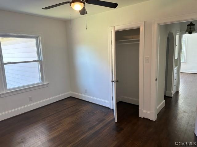 unfurnished bedroom with a closet, ceiling fan, and dark wood-type flooring