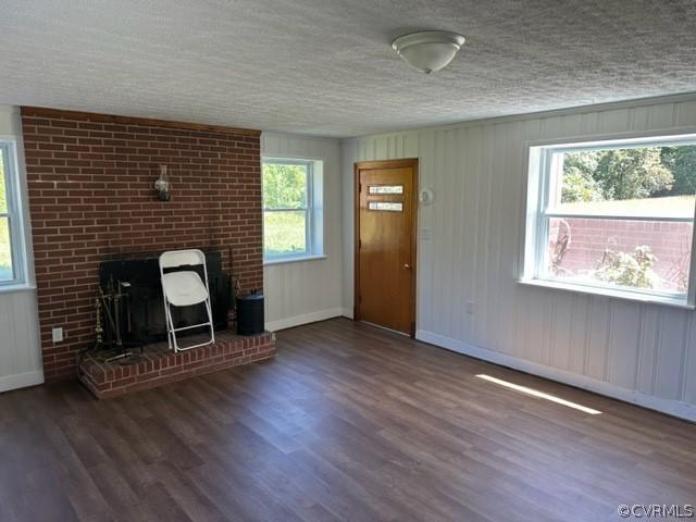 unfurnished living room featuring a textured ceiling and dark hardwood / wood-style floors