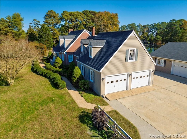 view of front of house featuring a garage, driveway, and a front lawn