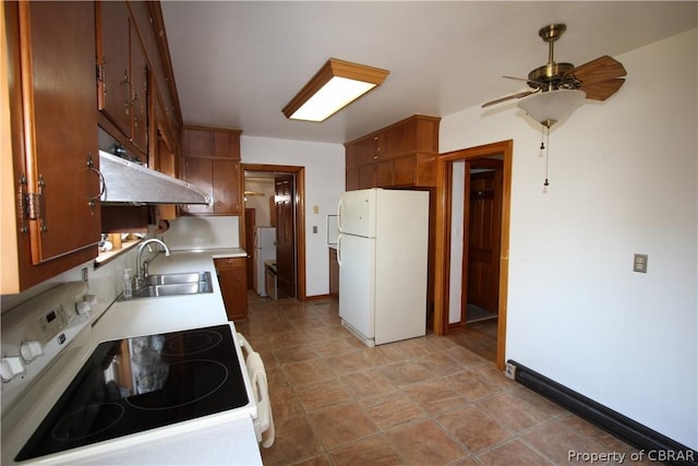 kitchen with white appliances, light countertops, a sink, and baseboards